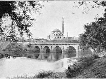 Το Πράσινο τέμενος (τζαμί του Χασάν μπέη) και η μεγάλη λίθινη γέφυρα της Λάρισας επί του Πηνειού.  Από το βιβλίο του Clive Bigham «With the Turkish Army in Thessaly». 1897. 