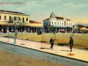 Η βόρεια πλευρά της Κεντρικής πλατείας (Δικαστηρίων ή Θέμιδος). Επιχρωματισμένο επιστολικό δελτάριο του Στέφανου Στουρνάρα, ταχυδρομημένο από τη Λάρισα την 1η Οκτωβρίου 1912
