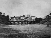 Η δυτική πλευρά του Λόφου της Λάρισας με τη γέφυρα και το τζαμί του Χασάν μπέη σε φωτογραφία δημοσιευμένη το 1888. Αρχείο Φωτοθήκης Λάρισας