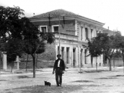 Σε μία από τις πόρτες του ισόγειου κτίσματος στο μέσον της φωτογραφίας στεγαζόταν  η Μουσική Σχολή Αχιλλέα Χατζηψαθά κατά τη διάρκεια του μεσοπολέμου.  Λεπτομέρεια από επιστολικό δελτάριο του Fr. Caloutas. Περίπου 1910. Αρχείο Φωτοθήκης Λάρισας. 