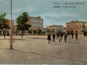 Η νοτιοδυτική πλευρά της Κεντρικής πλατείας. Επιχρωματισμένο επιστολικό δελτάριο του Κων. Παρασκευόπουλου. 1920 περίπου. Αρχείο Φωτοθήκης Λάρισας.