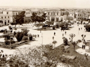 Η Κεντρική πλατεία στις δεκαετίες 1950-1960. Φωτογραφία του Νικολάου Στουρνάρα, η οποία απεικονίζει τη νοτιοδυτική πλευρά της, την οδό Κούμα και τα κτίριά της