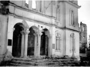 Η δυτική πλευρά του Μητροπολιτικού Ναού του Αγ. Αχιλλίου  με έντονες τις μεγάλες ζημιές που είχε υποστεί από τον σεισμό.  Δεξιά στο βάθος διακρίνονται υπολείμματα από το τριώροφο αρχοντικό  του Ιωάννη Βελλίδη. Αρχείο Φωτοθήκης Λάρισας.