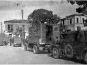 Πίσω από τα σταθμευμένα οχήματα του γερμανικού στρατού διακρίνεται μερικώς το κτίριο του Δημοτικού Ωδείου όπως ήταν προπολεμικά. Απρίλιος 1941. Αρχείο Φωτοθήκης Λάρισας