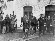 Λάρισα 1936. Ο βασιλιάς Γεώργιος Β΄ εξέρχεται του κτιρίου του Διεθνούς Σιδηροδρομικού Σταθμού, συνοδευόμενος από τον διάδοχο Παύλο και την ακολουθία του. Αρχείο Φωτοθήκης Λάρισας.
