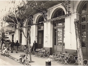 Το καφενείο «Νέος Κόσμος», στην ανατολική πλευρά  της Κεντρικής πλατείας. Είναι το μόνο το οποίο διατηρήθηκε και μεταπολεμικά.  Η φωτογραφία δείχνει ότι οι παλιοί μαστόροι είχαν γούστο και μεράκι.  Φωτογραφία Φωτοθήκης Λάρισας.