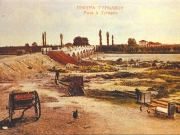 Επιχρωματισμένη φωτογραφία των αρχών του 20ού αιώνα όπου διακρίνεται η ιστορική γέφυρα του Τιταρήσιου, όπου έγινε η υποδοχή του Ελληνικού Στρατού και στο βάθος το Τουρκικό στρατόπεδο στο οποίο στεγάστηκε ο Ελληνικός Στρατός