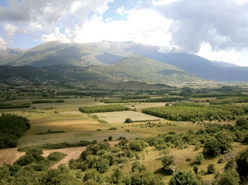 Το οροπέδιο Σκαμνιάς – Καρυάς και ψηλά ο Όλυμπος. Η φωτογραφία είναι από τα 1.100 μέτρα υψόμετρο