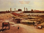 Επιχρωματισμένη φωτογραφία των αρχών του 20ου αιώνα όπου διακρίνεται η ιστορική γέφυρα του Τιταρήσιου που έγινε η υποδοχή του Ελληνικού Στρατού και στο βάθος το τουρκικό στρατόπεδο στο οποίο στεγάστηκε ο Ελληνικός Στρατός