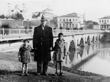 Λάρισα 1940. Ο Σπύρος Σ. Ποδάρας (γιος του Σωκράτη Ν. Ποδάρα) με τα παιδιά του (Κώστα και Σωκράτη) στη γέφυρα του Πηνειού.  © Αρχείο οικογενείας Σπύρου Σωκ. Ποδάρα.