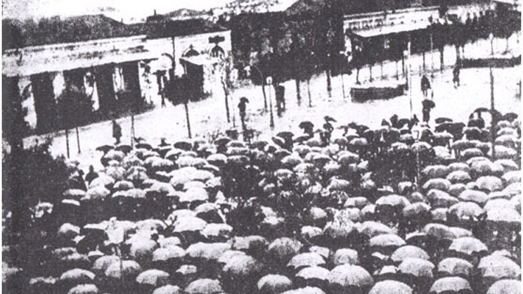«Την ημέραν της ομιλίας του Ελ. Βενιζέλου είχε ξεσπάσει ραγδαία βροχή». Μεγάλο πλήθος  με ομπρέλες παρακολουθεί την ομιλία του στην Πλατεία Θέμιδος (Κεντρική πλατεία)».