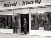 Το εμπορικό κατάστημα Ντίνας-Ντώνης. Στην είσοδο αριστερά ο Βαγγέλης Βοζαλής και δεξιά ο Μίνως Ντίνας. Φωτο-Φελουζάκης. 1954. Αρχείο Βαγγέλη Βοζαλή