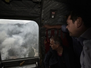 Ο πρωθυπουργός Αλέξης Τσίπρας, εν πτήσει, κοιτάζει τις καμμένες περιοχές της Θάσου μέσα από το παράθυρο του ελικοπτέρου
