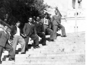 Μια ομάδα έξι καλοντυμένων νεαρών φωτογραφίζεται συμμετρικά με την ίδια στάση στα σκαλοπάτια του Αγ. Αχιλλίου. Προπολεμική φωτογραφία.