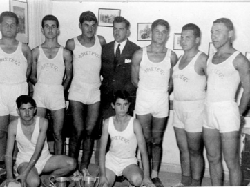 Η ομάδα μπάσκετ του «Αριστέα» στα γραφεία του Συλλόγου έπειτα από την κατάκτηση κάποιου κυπέλλου. Από αριστερά όρθιοι οι Παπαθεοδώρου Ιωάννης-Νικολίτσας Μέμος-Ντουβής Μάρκος-Μενέλαος Κονταξής, έφορος της ομάδας -Μακρυγιάννης Τόλιος-Παπαθεοδώρου Νικόλαος-Κουσέρας Νικόλαος. Καθιστοί, αριστερά Παπαθανασίου (Πασαδάκιας) Πέτρος και δεξιά Κέλλας Ευάγγελος. 27 Δεκεμβρίου 1955.