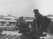Τα κτίρια της νοτιοανατολικής γωνίας της Κεντρικής πλατείας (Θέμιδος) στα τέλη της δεκαετίας του 1920. Λεπτομέρεια από επιστολικό δελτάριο του φωτογράφου Ιωσαφάτ από τον Βόλο. Συλλογή Αντώνη Γαλερίδη