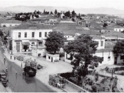 Δεξιά διακρίνεται το κέντρο που είχε κτίσει ο Πέτρος Χαλήμαγας στην πλατεία Ανακτόρων. Σήμερα υψώνεται το κτίριο του Δημοτικού Ωδείου. Λεπτομέρεια από μεταπολεμική φωτογραφία του Τάκη Τλούπα. 1950