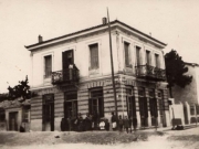 Το διώροφο κτίριο που οικοδόμησε ο Νικόλαος Νικόδημος το 1906, στη γωνία των οδών Καραϊσκάκη και Φαρμακίδου. Το ισόγειο το διαμόρφωσε σε οινοπωλείο, ενώ στον όροφο διέμενε η οικογένεια. Φωτογραφία των αρχών της δεκαετίας του 1930. Αρχείο οικογένειας Νικόδημου