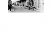 Η οδός Ερμού φωτογραφημένη από την οδό Βενιζέλου τον Απρίλιο του 1941, μετά τον σεισμό και κατά τη διάρκεια της γερμανικής κατοχής. Ο τοίχος από το κατάστημα των αδελφών Κουτσίνα έχει κρημνισθεί. Από το βιβλίο &quot;Η Μνήμη της πόλης. Λάρισα. Κατοχή -Απελευθέρωση. 1941-1944&quot;. Αρχεία Βυρ. Μήτου και άλλων. Επιμέλεια Φωτοθήκης Λάρισας (2018) σελ. 98