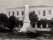 Η προτομή του Κωνσταντίνου Κούμα στη βορειοδυτική γωνία της Πλατείας Θέμιδος. Πίσω προβάλλει το ξενοδοχείο &quot;Το Στέμμα&quot;. Επιστολικό δελτάριο του Λαρισαίου τυπογράφου Α. Παναγιωτακόπουλου. Περίπου 1932